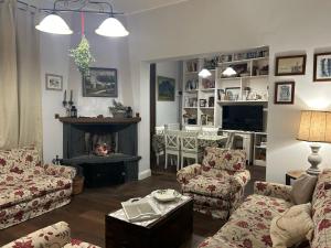 a living room with a fireplace and a couch and chairs at Casa di Paco a Nicolosi in Mascalucia
