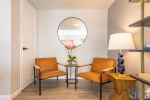 a living room with two chairs and a mirror at Downtown Manhattan Beach 3 Bed Townhouse Parking in Manhattan Beach +26 photos