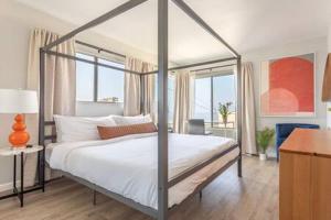 a bedroom with a canopy bed with a window at Downtown Manhattan Beach 3 Bed Townhouse Parking in Manhattan Beach