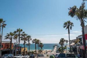 una strada cittadina con palme e l'oceano di Downtown Manhattan Beach 3 Bed Townhouse Parking a Manhattan Beach