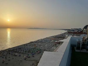 uma praia com guarda-sóis e uma multidão de pessoas em Studio apartment next to 5* resorts, Golem em Durrës