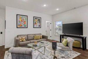 a living room with a couch and a tv at The Warhol - Pet-Friendly Apartment in Bentonville