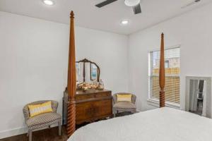 a bedroom with a bed with a mirror and two chairs at The Warhol - Pet-Friendly Apartment in Bentonville