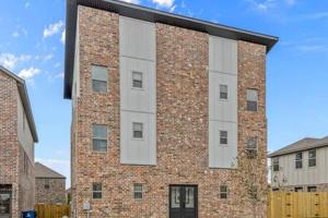 a large brick building with a white facade at The Warhol - Pet-Friendly Apartment in Bentonville