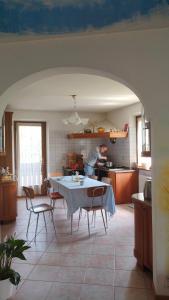 een keuken met een tafel en stoelen en een man in de keuken bij Villa Cares - Pension mit Tischtennis in Cares