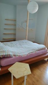 a bed with a wooden frame and a table at Villa Cares - Pension mit Tischtennis in Cares