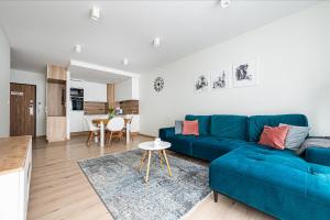 a living room with a blue couch and a table at Posejdon - BillBerry Apartments in Gdańsk