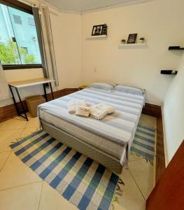 ein Schlafzimmer mit einem Bett mit zwei Handtüchern darauf in der Unterkunft Casa da Lilyan in Visconde De Maua