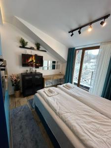 een slaapkamer met een groot bed en een televisie bij N Lux 95 Milmari in Kopaonik