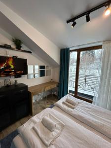 een slaapkamer met 2 bedden, een tv en een raam bij N Lux 95 Milmari in Kopaonik