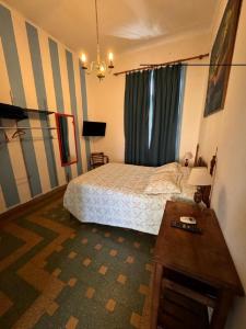 Un dormitorio con una cama y una mesa. en Casa Chango Hostel en Tandil