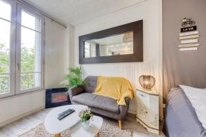 - un salon avec un canapé et un miroir dans l'établissement Le Peper - RER B - La place - Paris - Orly, à Arcueil