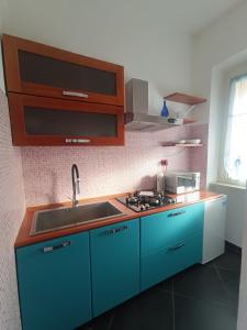 una cucina con armadi blu e lavandino di La Casa del Capo - appartamento con 2 camere. a Venaria Reale