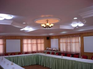 una sala de conferencias con mesas, sillas y una lámpara de araña en Hotel Mount View, en Kodaikanal