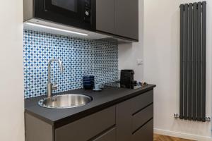 a kitchen counter with a sink and a microwave at L'Incanto House in Salerno +5 photos