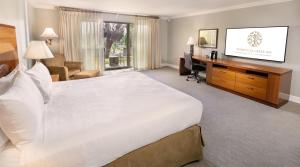 ein Hotelzimmer mit einem großen Bett und einem Schreibtisch in der Unterkunft Temecula Creek Inn in Temecula