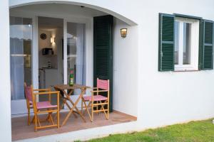 une table et des chaises sur une terrasse avec une fenêtre dans l'établissement Apartamento Sol Isla Arenal de'n Castell, à Arenal d'en Castell