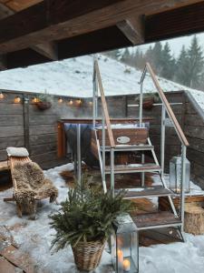 a patio with a wooden table and stairs in the snow at Chata Sękata in Baligród