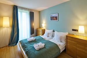 a bedroom with a large bed with towels on it at Aparthotel Lípa in Krásná Lípa