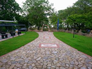 a stone walkway in a park with a building and grass at Hotel Hlidi in Kokkino Nero