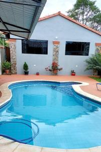 uma grande piscina azul em frente a uma casa em Mar Azul em San Lorenzo