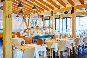 a restaurant with white tables and chairs and windows at Aparthotel Lípa in Krásná Lípa