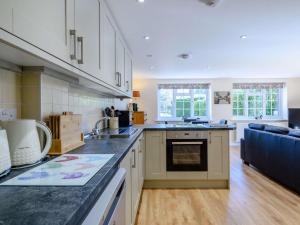 a kitchen with white cabinets and a black counter top at 2 Bed in Melton Constable 75761 in Briston