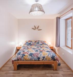 Schlafzimmer mit einem Bett und einem Fenster in der Unterkunft Gite aux 1000 chemins - Apt 50m2 in Saint-Joseph-de-Rivière