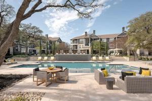 un patio con mesa y sillas junto a una piscina en Elegant 1BR with resort style pool near The Domain, en Austin