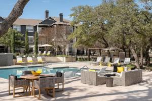 un patio con mesa y sillas junto a una piscina en Elegant 1BR with resort style pool near The Domain, en Austin