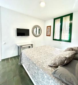 a bedroom with a bed and a flat screen tv at Optimist Playa de Las Américas in Playa de las Americas
