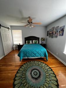 um quarto com uma cama com um edredão azul e um tapete em The Peacock House em San Antonio