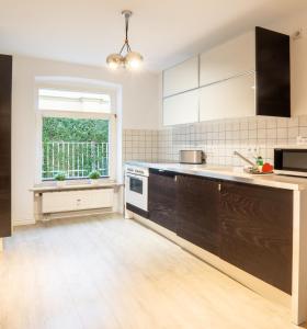 cocina con electrodomésticos blancos y ventana grande en Charlot, en Heringsdorf
