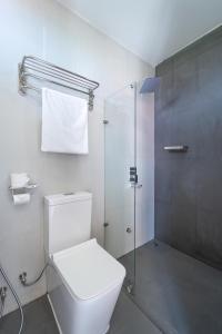 a white bathroom with a toilet and a shower at Silver Oasis Maldives in Huraa