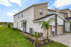 a white house with palm trees in front of it at Dazzling Thematic 2BR with Game Room in Davenport