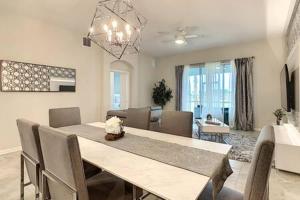 a dining table and chairs in a living room at Dazzling Thematic 2BR with Game Room in Davenport
