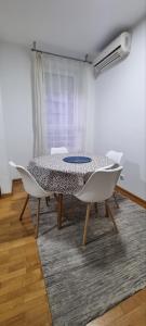 a dining room with a table and white chairs at Mimoza in Novi Beograd