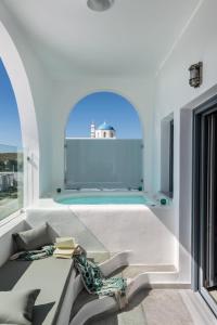 メガロホリにあるAspronisi Luxury Villa with Caldera Viewのスイミングプールとテーブル付きの客室です。