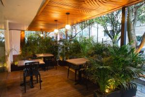 un restaurante con mesas, sillas y macetas en Hotel Laureles Loft, en Medellín