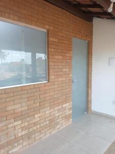 un mur en briques avec une porte et une fenêtre dans l'établissement Apartamento-Chalé, à Prado