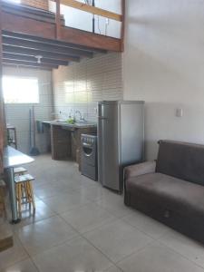 Il comprend une cuisine équipée d'un réfrigérateur en acier inoxydable et d'un canapé. dans l'établissement Apartamento-Chalé, à Prado