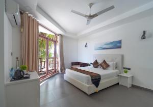 a bedroom with a bed and a large window at Silver Oasis Maldives in Huraa