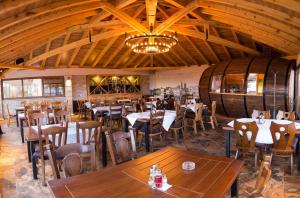 a restaurant with tables and chairs and a large room with wine barrels at Motel Konak Mosko in Trebinje