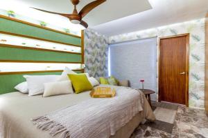 a bedroom with a large bed with yellow and green walls at Limoná Suite Jardín. Fresh Elegance Jacuzzi & A.C. in Guadalajara