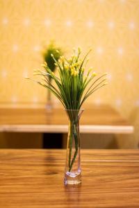 a vase filled with yellow flowers sitting on a table at Limoná Suite Jardín. Fresh Elegance Jacuzzi & A.C. in Guadalajara