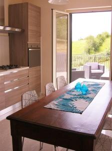 una cocina con una mesa de madera con sillas alrededor. en Diamante House 763, en Atina