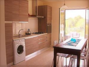 cocina con lavadora y mesa con sillas en Diamante House 763, en Atina
