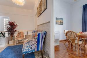 a living room with a chair and a table at Requinte e bom gosto para 6 pessoas no coração de Faro in Faro