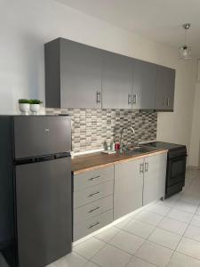 a kitchen with white cabinets and a sink and a refrigerator at Tony 's place in Drama