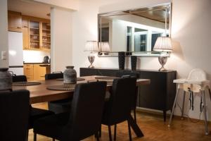 a dining room with a table and chairs and a mirror at Villa Mänty 200 m2 Korkeatasoinen kaupunkikoti in Seinäjoki